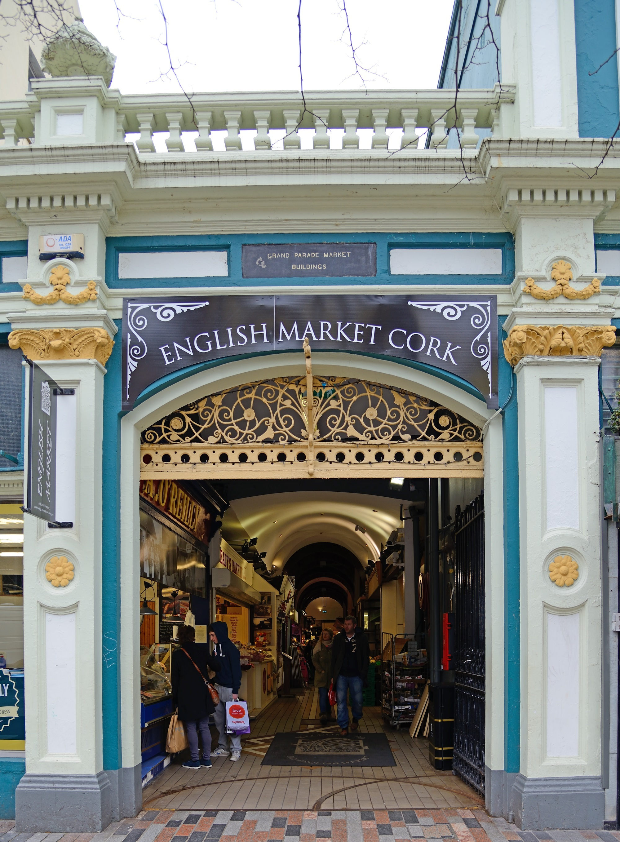 The Grand Parade entrance to the English Market, with the historic Grand Parade Market Buildings plaque still visible above.